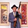 William Burroughs posing with two 'shotgun paintings'