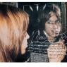 Iggy Pop through the glass, darkly, by Mick Rock, in a print featuring the scrawled lyrics of 'Raw Power'. Signed by Pop and Rock