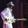 Larry Graham wears a blinding white suit and hat and leads from the front