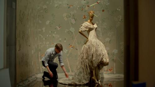 Andrew Bolton, curator at the Met's costume institute, adjusts an art work