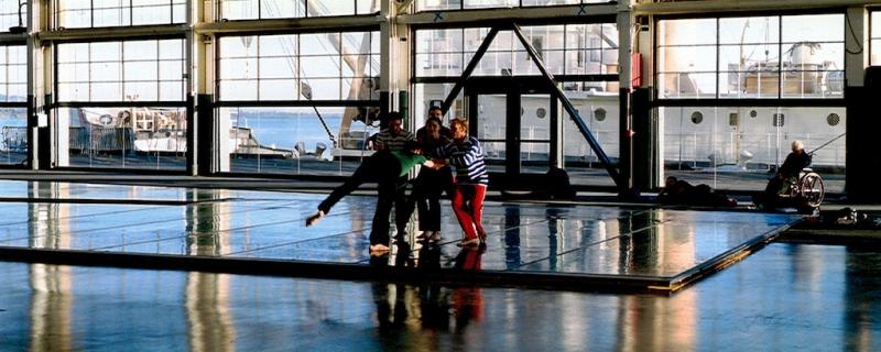 'Against the light, the dancers appear like marionettes framed within grids of glass and steel' 'Against the light, the dancers appear like marionettes framed within grids of glass and steel'