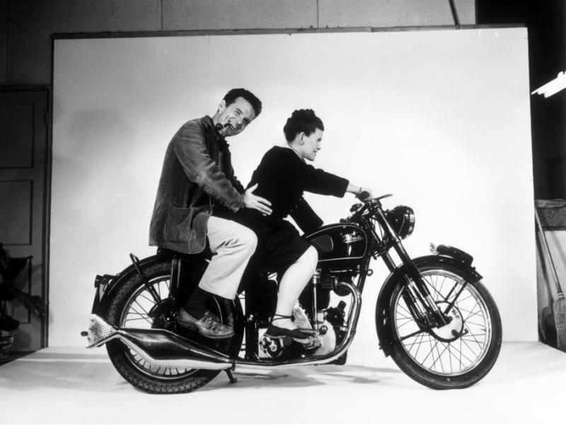 Charles and Ray Eames posing on a Velocette motorcycle, 1948