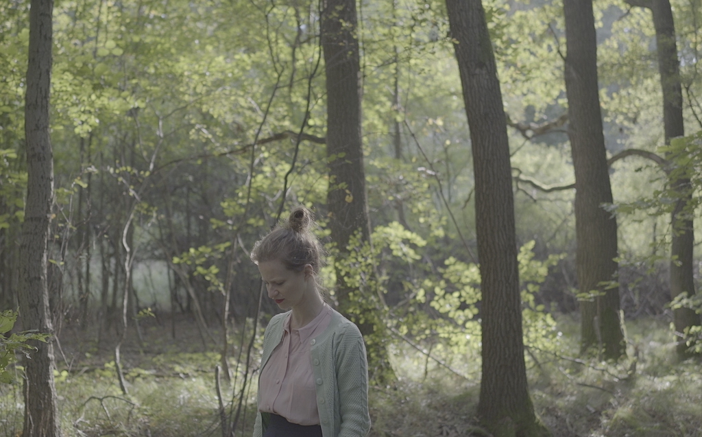 Liv Migdal sings in a birch wood. Still from The Last Musician of Auschwitz