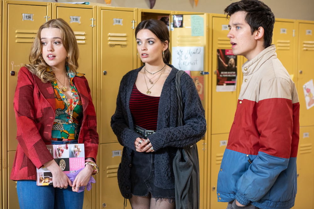 Aimee Lou Wood, Emma Mackey and Asa Butterfield in the Moordale High hallway