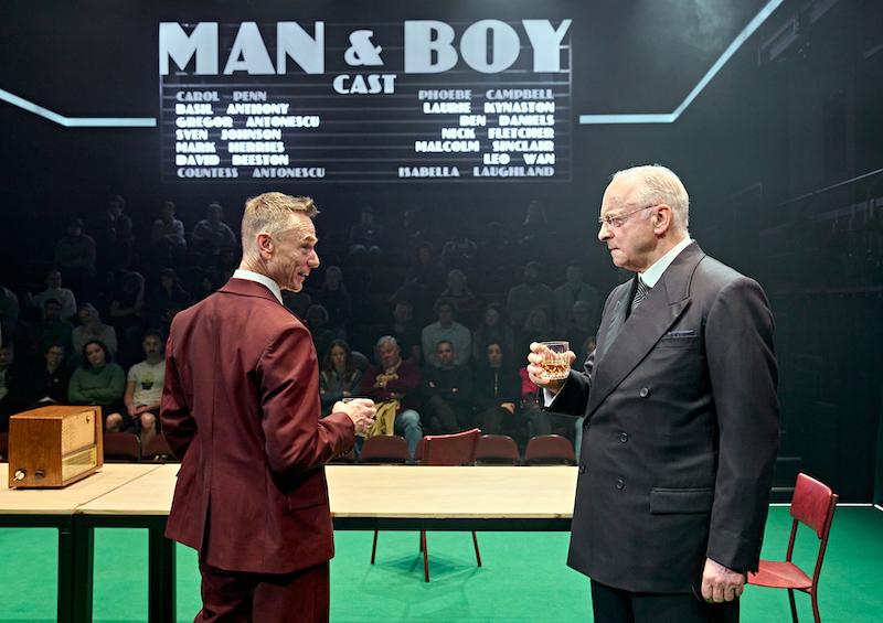 Ben Daniels and Malcolm Sinclair facing each other on stage