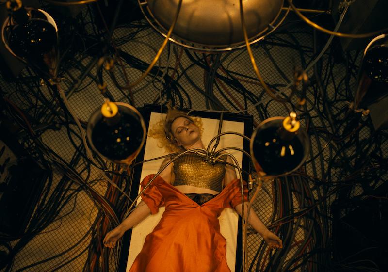 Jessie Buckley as Ida unconscious on a table with electric cables running into her body